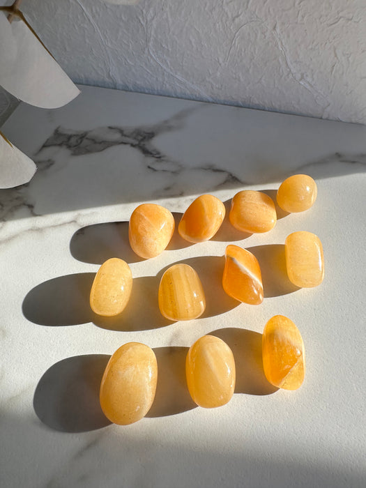 Orangencalcit Trommelstein