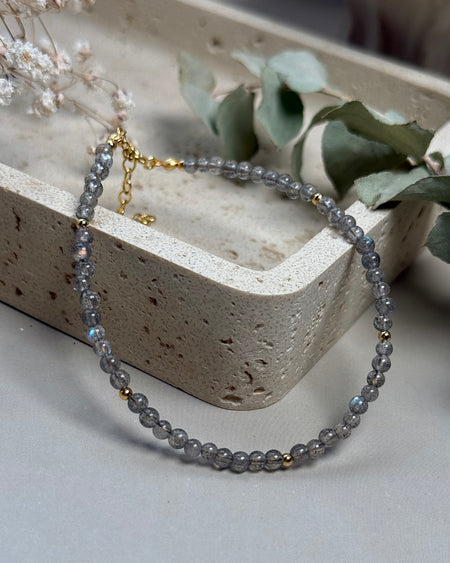 Labradorit-Kugelarmband mit vergoldeten 925er Silberelementen, schimmernd, 18–23 cm, mit Verlängerungskette, auf hellem Hintergrund.