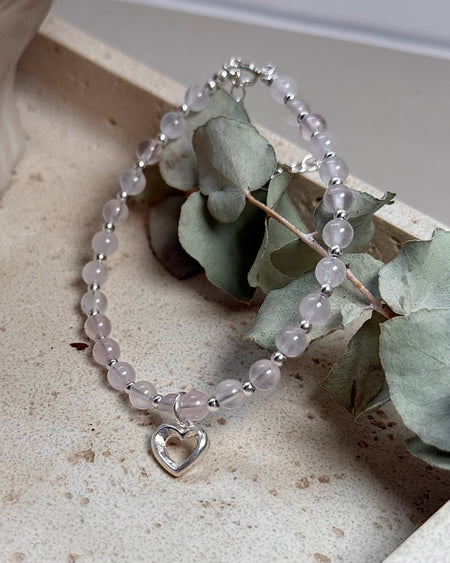 Rosenquarz-Armband mit Herzanhänger und 925er Silberperlen, zart rosé, verstellbar 18–22 cm, auf hellem Hintergrund.