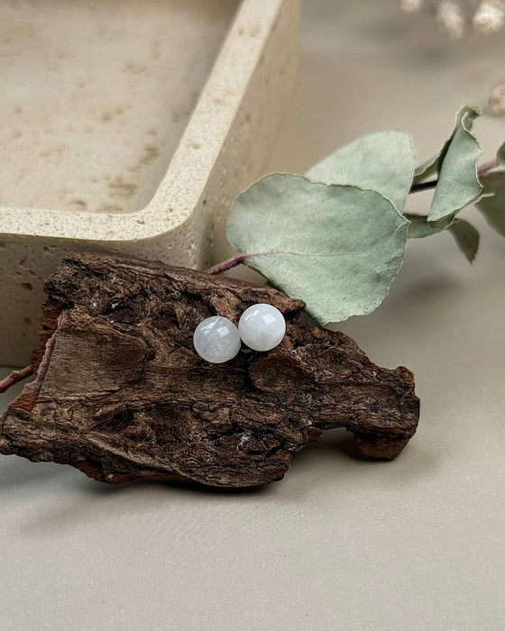 Weiße Labradorit-Ohrstecker aus rhodiniertem 925er Silber, 6 mm Kugeln, schimmernd, auf hellem Hintergrund.