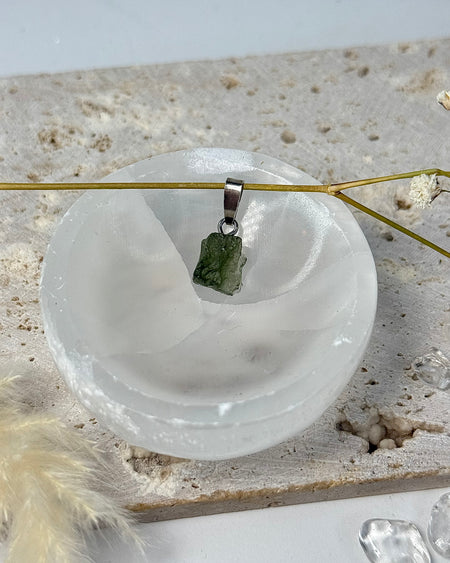 Roh-Moldavit Anhänger mit natürlicher Struktur und 925er Silberöse, etwa 1 cm groß.