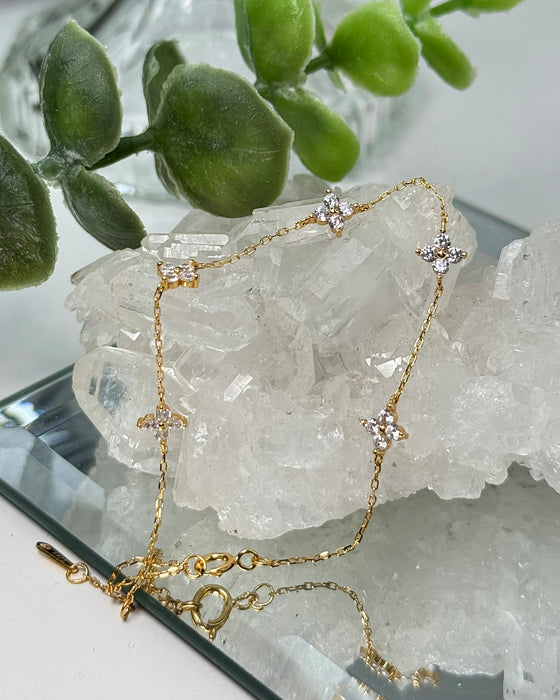 Zartes Goldarmband mit funkelnden Blütenanhängern aus Zirconia