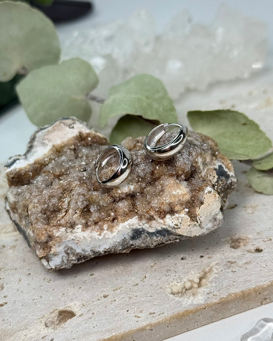 Filigrane 925er Silbercreolen mit 1,3 cm Durchmesser auf hellem Hintergrund.