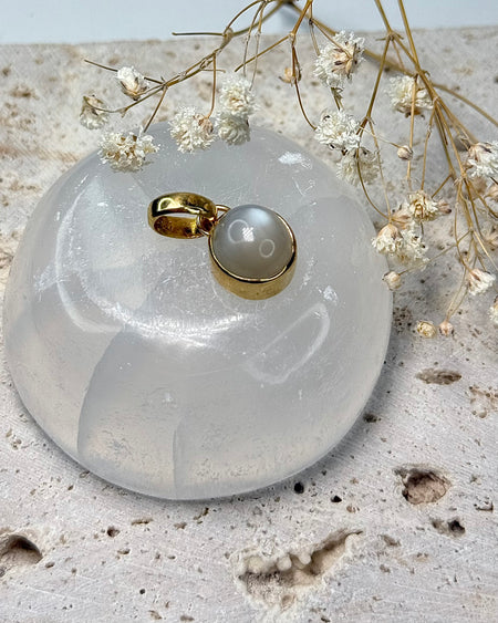 Runder Mondstein-Anhänger im vergoldeten 925er Silber, 1,2 cm Durchmesser, auf hellem Hintergrund.