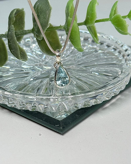 Facettierter Aquamarin-Anhänger, in 925er Silber gefasst, auf hellem Hintergrund.