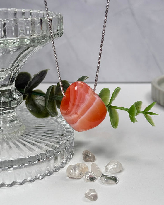 Aprikosenachat, gebohrter Anhänger, 2,7 cm, warm apricotfarbener Naturstein mit sanften Farbschichten.