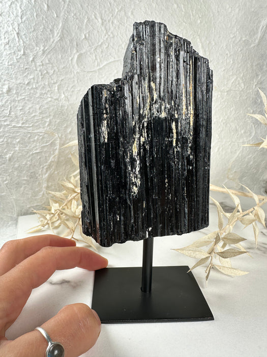 Schwarzes Turmalin Rohstück auf Metallständer E119