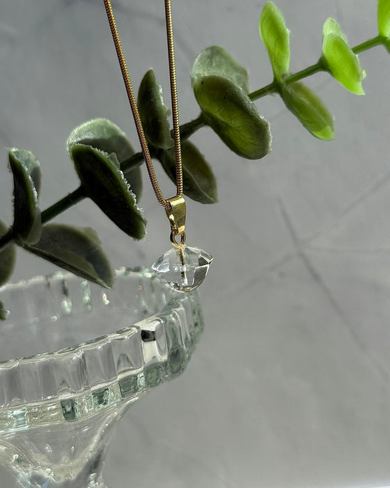 Zarter Anhänger aus facettiertem Bergkristall mit vergoldeter 925er Silberöse, Länge 1,2 cm – funkelnder Edelstein-Schmuck in klarer Optik.
