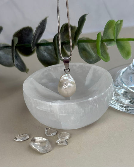 Dieser elegante Süßwasserperlen-Anhänger besticht durch seinen natürlichen Lüster und seine klassische Form. Mit einer Länge von 1,4 cm (ohne Öse) ist er dezent und dennoch ein ausdrucksstarker Blickfang, der jedem Outfit eine edle Note verleiht.

Die hochwertige 925er Silberöse sorgt für sicheren Halt und macht den Anhänger vielseitig tragbar. Ob an einer feinen Silberkette oder in Kombination mit weiteren Schmuckstücken – dieser Anhänger lässt sich stilvoll in Szene setzen und bleibt dabei zeitlos schön.
