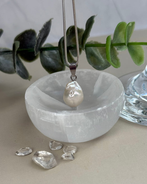 Dieser elegante Süßwasserperlen-Anhänger besticht durch seinen natürlichen Lüster und seine klassische Form. Mit einer Länge von 1,4 cm (ohne Öse) ist er dezent und dennoch ein ausdrucksstarker Blickfang, der jedem Outfit eine edle Note verleiht.

Die hochwertige 925er Silberöse sorgt für sicheren Halt und macht den Anhänger vielseitig tragbar. Ob an einer feinen Silberkette oder in Kombination mit weiteren Schmuckstücken – dieser Anhänger lässt sich stilvoll in Szene setzen und bleibt dabei zeitlos schön.
