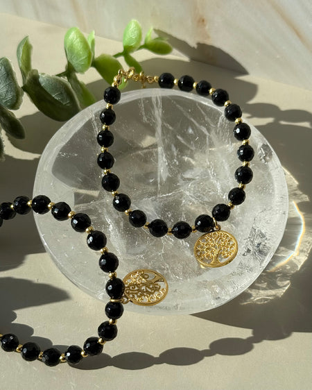 Schwarzes Turmalin-Armband mit 6 mm facettierten Perlen, vergoldeten 925er Silberelementen, Verlängerungskette und Lebensbaumanhänger.