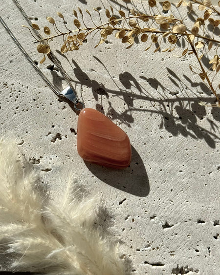 Roter Chalcedon-Anhänger, poliert, mit 925er Silberöse, Länge 2,5 cm.